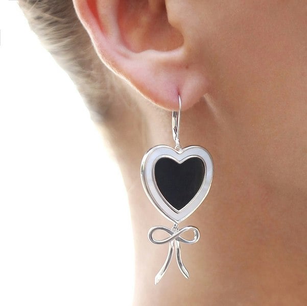 Close up of an ear with black and white heart earrings.