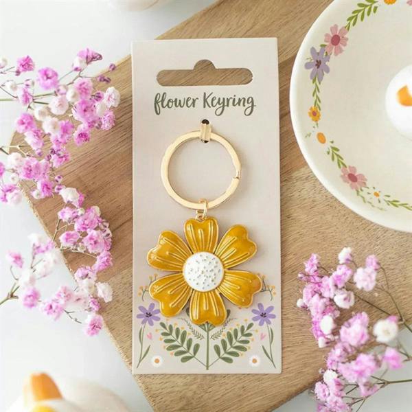 Yellow daisy flower keyring with gold-tone ring and daisy pendant on card