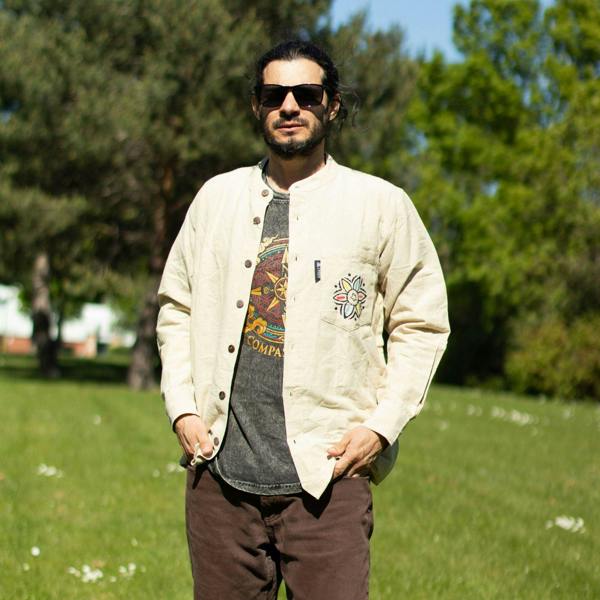 Cream button-front top with patterned chest detail and small logo patch