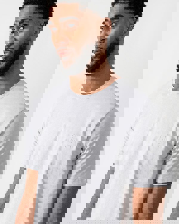 close up of a model wearing a BOSS Orange Tales Mens Cotton-Jersey T-shirt With Logo Patch in Light-Pastel Grey