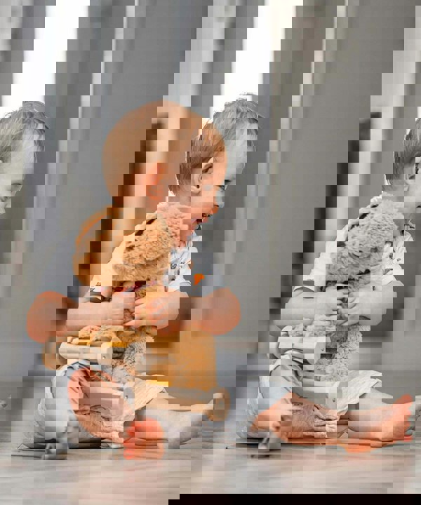 Little boy hugging dexter dog toy  