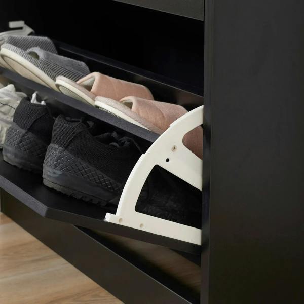 Close-up of open flip door showing shoe pairs in a black narrow shoe cabinet