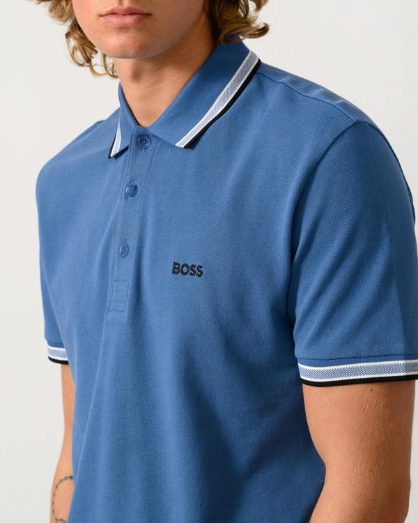 a close up studio photograph of a model wearing a BOSS Green Paddy Mens Cotton-Piqué Polo Shirt with Contrast Logo in Medium Blue 428
