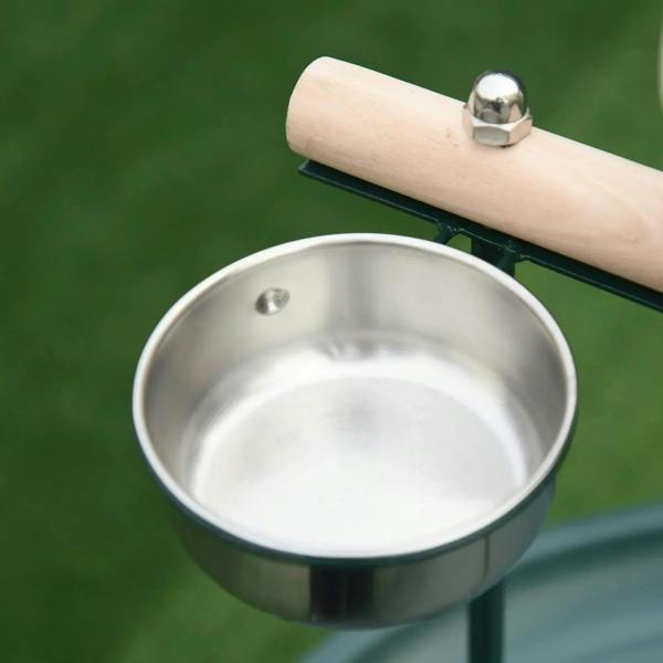 Stainless steel bird feeding bowl with attached perch bar on green stand