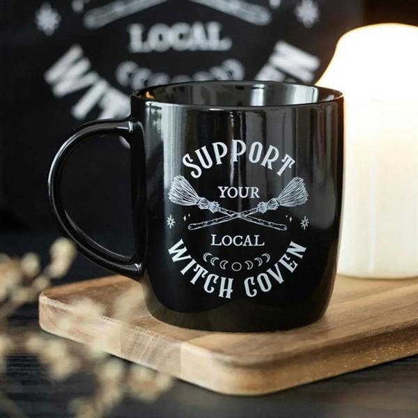 Black ceramic mug with 'Support Your Local Witch Coven' print and curved handle