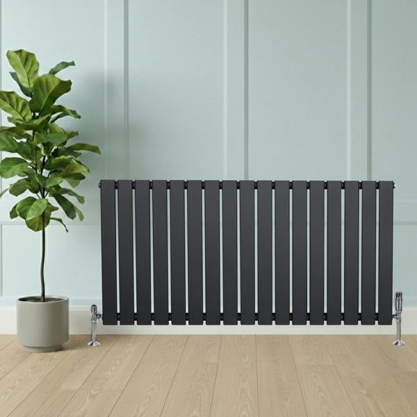 Flat single column radiator in anthracite grey, featuring sleek vertical bars, positioned against a light wall with a potted plant nearby