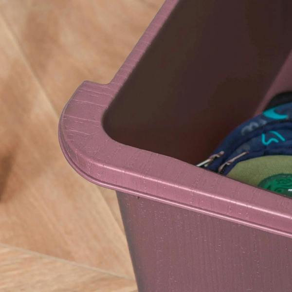 Pink lower drawer corner of 3-tier plastic storage unit with rounded lip and base edge