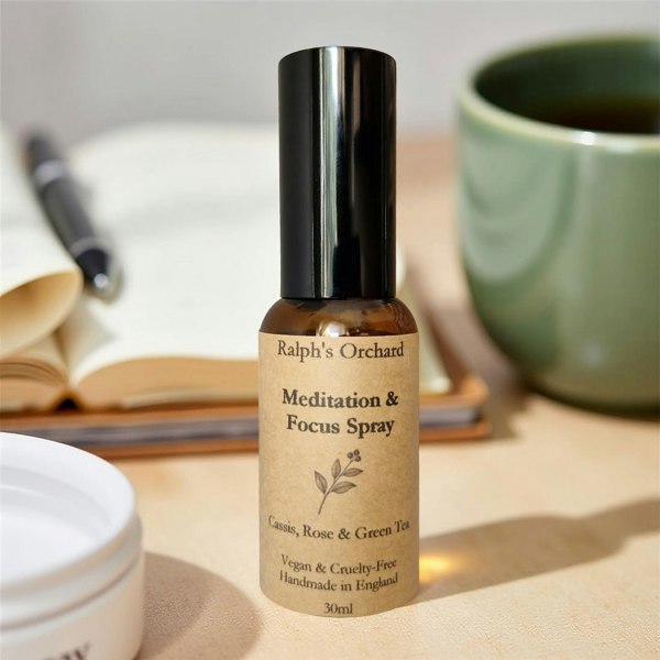 Bottle of Ralph's Orchard Meditation & Focus Spray on a table with a book and mug in the background