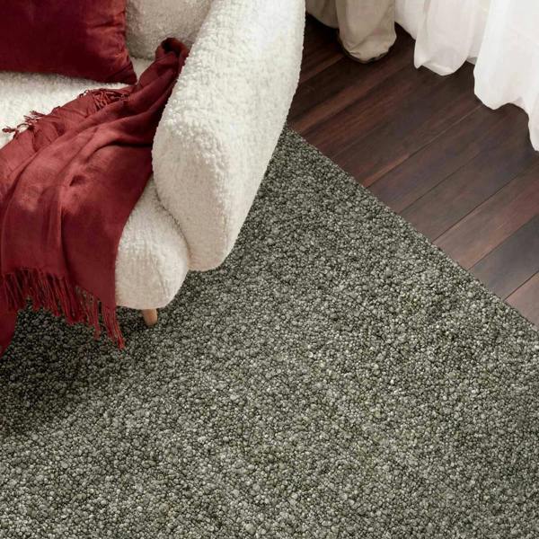 Gray carpeted floor with a white sofa and red blanket in the foreground