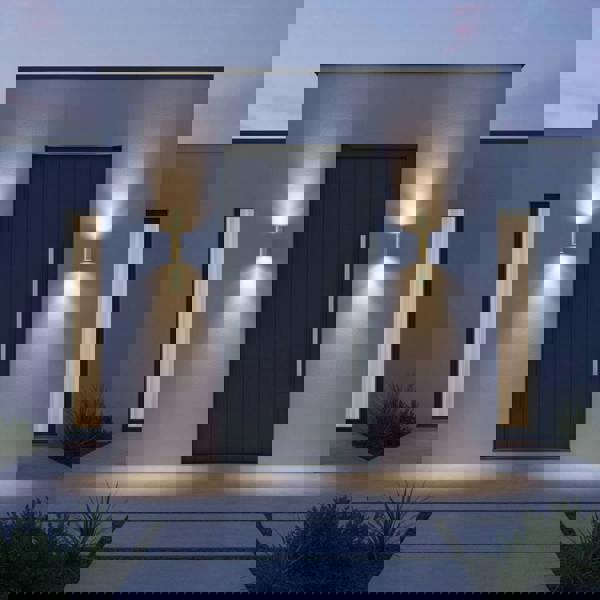 brass up down outdoor wall light installed either side of the front door of a home 