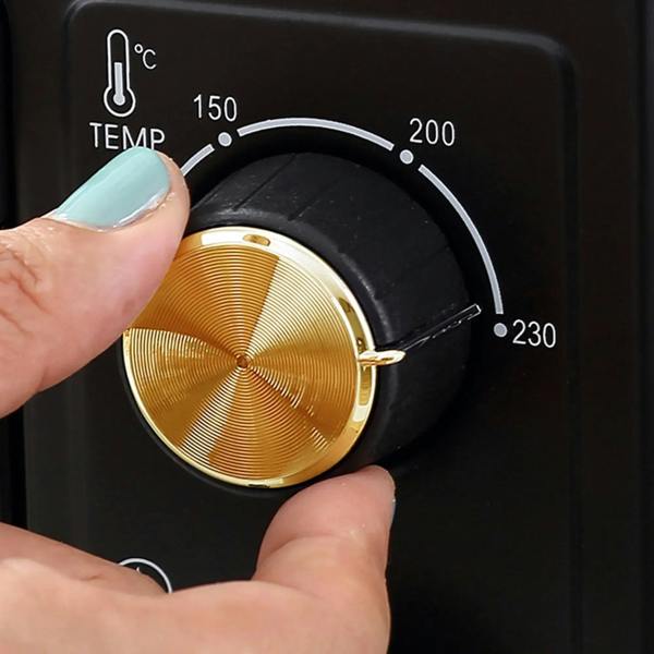 Black countertop oven temperature dial with gold knob marked 150 to 230°C