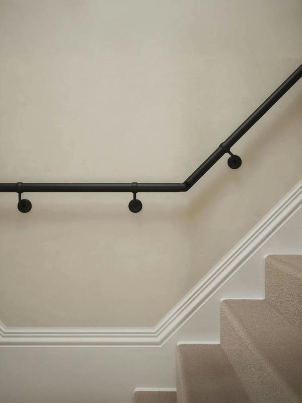 Close-up of Kineton Matt Black wall-mounted handrail with brackets on a T-shape staircase – Handrails Direct UK supplier of modular indoor handrails and fittings