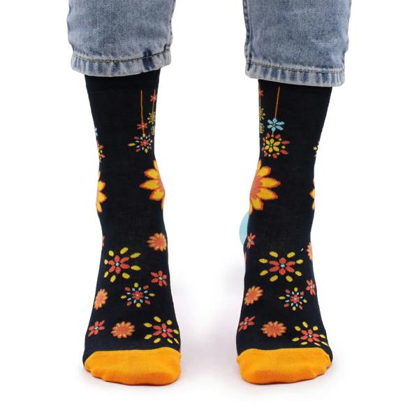 Black crew socks with orange and yellow flower mandala prints, light blue toe and heel