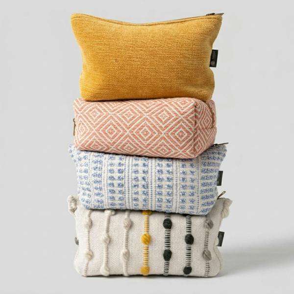 Stack of toiletry bags with indigo jacquard pouch at the bottom