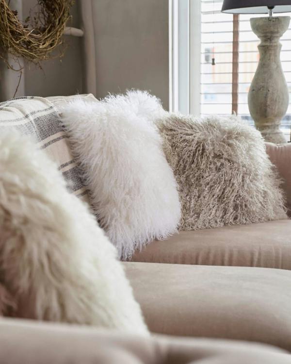 Grey and white mongolian sheepskin pillows on sofa