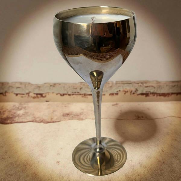 Silver cocktail glass on a textured surface with a warm glow