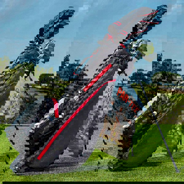 a bag of golf clubs sitting on top of a green field