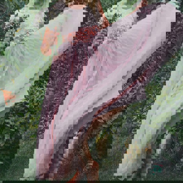 Girl standing outdoors among greenery