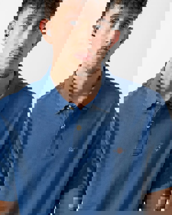 close up shot of a Model wearing a GANT Mens Regular Fit Short Sleeve Shield Logo Pique Polo in Vintage Blue