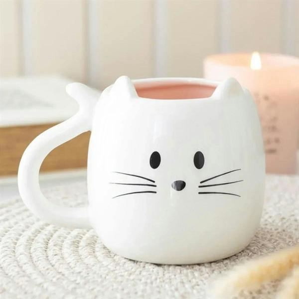 Cat-shaped ceramic mug, white with black whisker face and pink interior