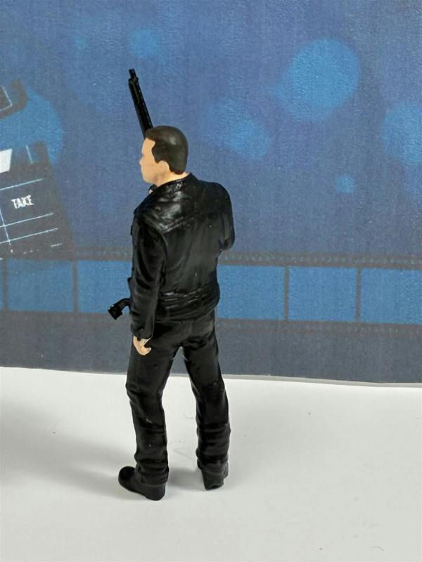 a toy figure of a man holding a gun