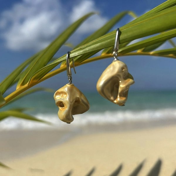 Demi-fine shell earrings electroplated in gold by LENAE London shot on a stunning beach.