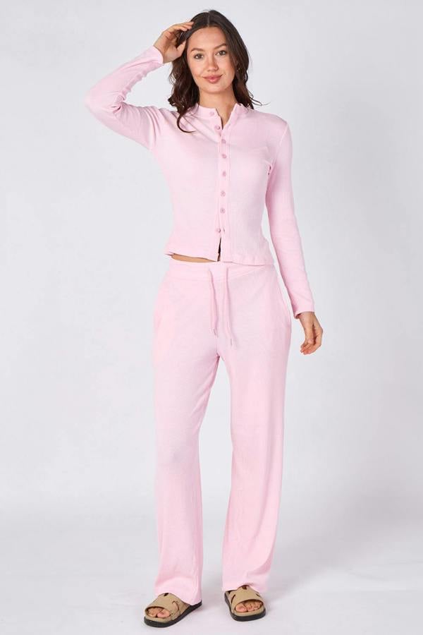 Woman wearing a pink pajama set on a white background