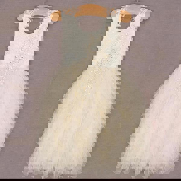 White floral dress on a hanger against a plain background