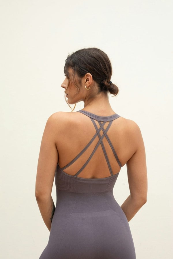 Model wearing grey one piece for sustainable activewear brand, JillaTwilight ash light brown purple seamless sculpting shaping one piece bodysuit with built in shelf bra and removable pads for yoga, pilates, gym and exercise.