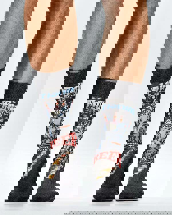 Black socks with fishing and beer-themed designs worn by a person on a white background