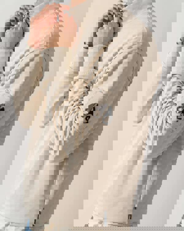 close up shot of a model wearing a Moose Knuckles Hartsfield Mens 1/4 Zip Sweatshirt in Alabaster 1705