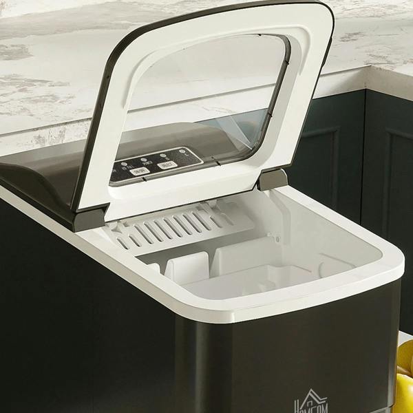 Black ice cube machine open lid with white interior tray and control buttons
