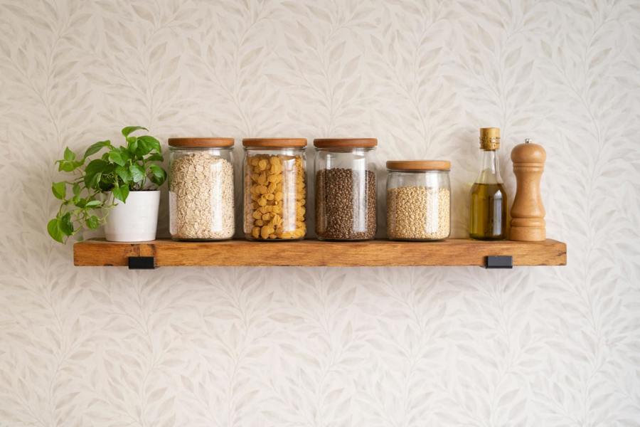 Natural oak reclaimed scaffold board shelf styled in kitchen with jars and plant