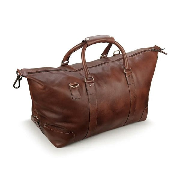 Angled view of the brown leather holdall, emphasizing its spacious design and reinforced stitching.