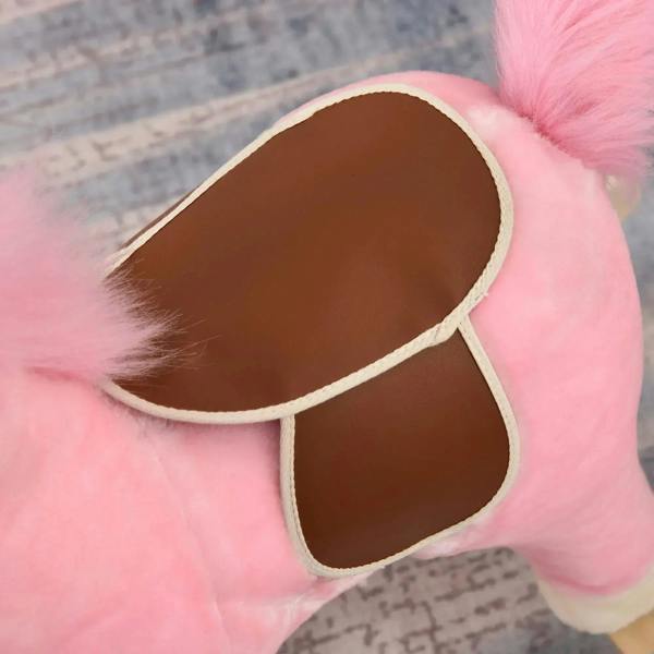 Close-up of brown open saddle pocket on pink plush rocking horse