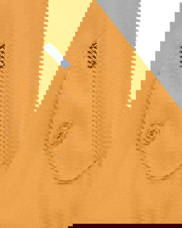 Lambretta Mens ShowerProof Classic Harrington MOD Scooter Jacket Coat, close-up of a tan-colored jacket with a pocket featuring a Lambretta tag and a button engraved with 'Lambretta'.