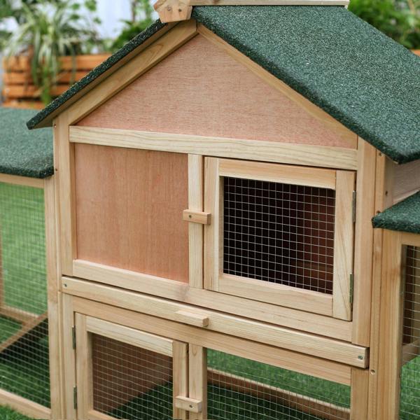 Wooden rabbit hutch door with wire mesh window under a green felt roof