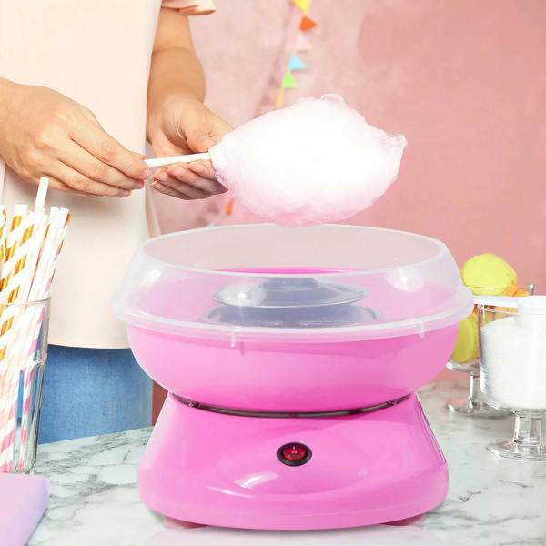 Pink electric cotton candy maker producing a fluffy cotton candy cloud