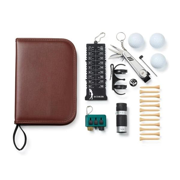 A top-down flat-lay shot displaying the closed cognac brown faux leather zippered case next to its 20 contents, including 3 golf balls, 12 wooden tees, a perpetual score keeper, a 7x18 monocular, a multi-function pocket tool, a ball clip, and a teal cleaning brush.