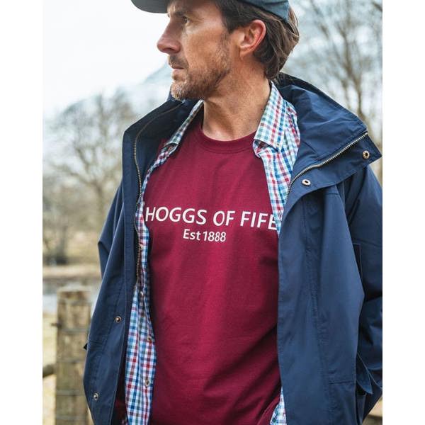 Man wearing Hoggs of Fife Canonbie t-shirt in burgundy layered under jacket outdoor country wear