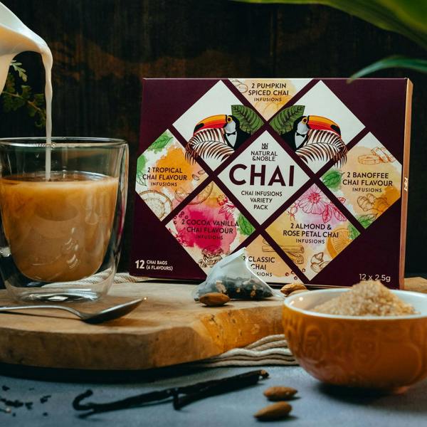 Milk Pouring into a Mug of Natural & Noble Chai, Alongside the Variety Pack