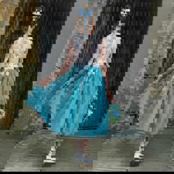 young girl holding her skirt
