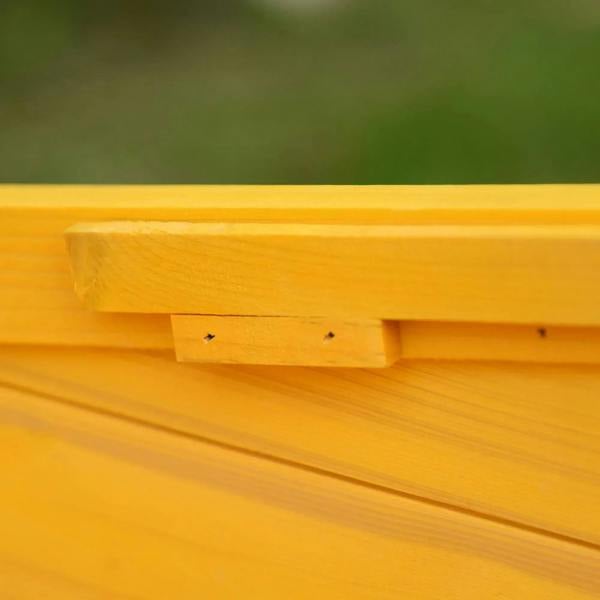 Yellow wooden cat house roof edge detail with visible screws