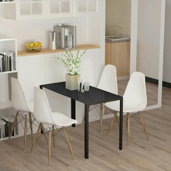 Black rectangular dining table with tempered glass top and metal legs, styled with chairs
