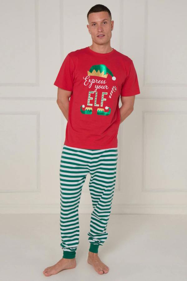 Man wearing a red t-shirt with a Christmas design and green and white striped pants on a white background