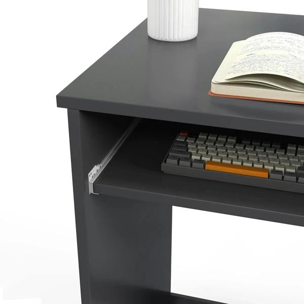Grey keyboard tray and desktop corner with book on the compact computer desk