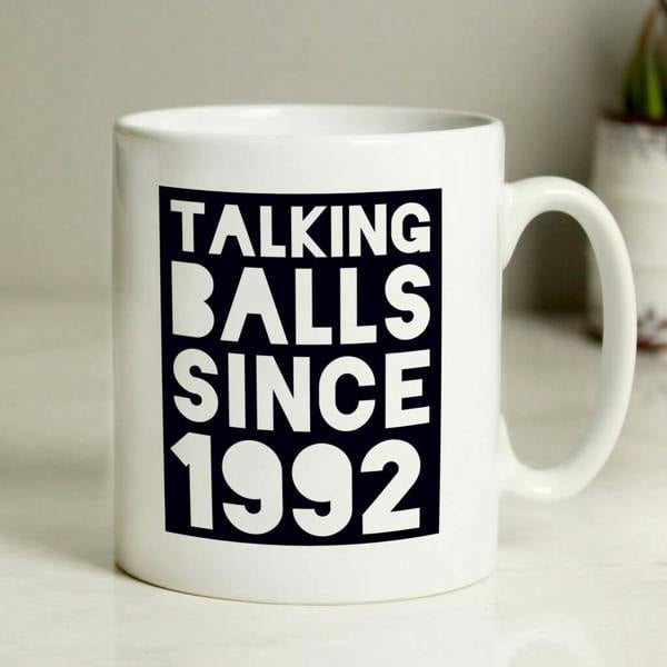 A white ceramic mug featuring a bold navy blue graphic square block filled with white text that reads 'TALKING BALLS SINCE 1992'.
