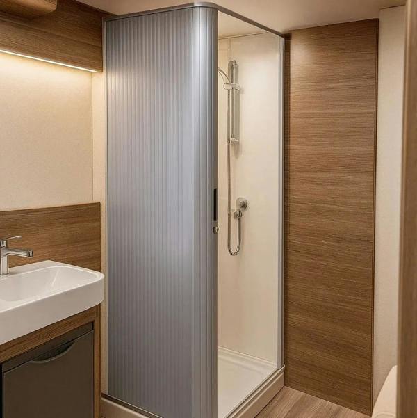 Silver Tambour shower door with vertical grooves, sleek design, and modern finish, set in a stylish bathroom with wood accents