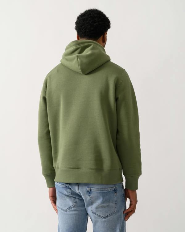 back shot of a model wearing a GANT Mens Regular Fit Shield Logo Pullover Hoodie in 379 Dry Herb Green