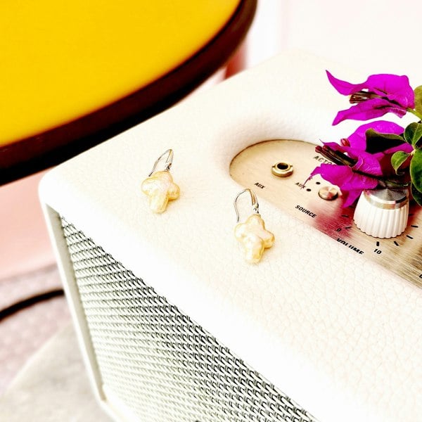 Freshwater baroque pearl cross earrings displayed on a vintage Artdeco radio.